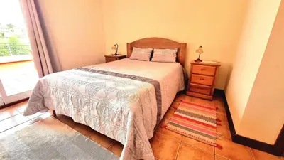 a bedroom with a bed and a dresser and a window at Casa Gouveia in Porto Santo