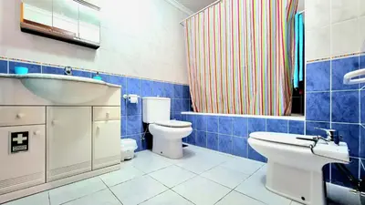 a blue and white bathroom with a toilet and a sink at Casa Gouveia in Porto Santo