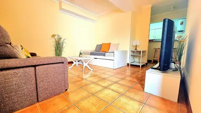 a living room with a couch and a flat screen tv at Casa Gouveia in Porto Santo