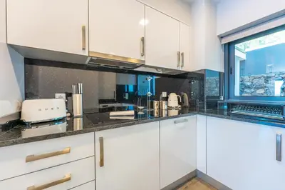a kitchen with white cabinets and a window at FLH Amazing Ocean View with Balcony in Santa Cruz