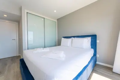 a bedroom with a large white bed with a blue headboard at FLH Amazing Ocean View with Balcony in Santa Cruz