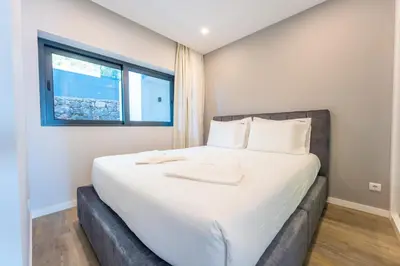 a bedroom with a large white bed with a window at FLH Amazing Ocean View with Balcony in Santa Cruz