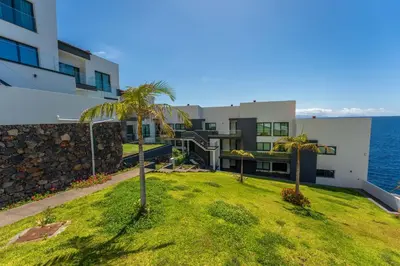 a house with palm trees in front of the ocean at FLH Amazing Ocean View with Balcony in Santa Cruz