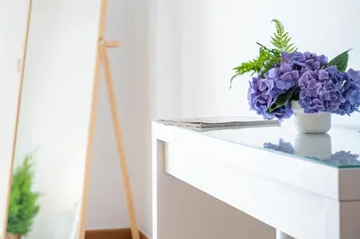 a vase of purple flowers on a white dresser at Lovely apartment at the best location in Funchal in Funchal