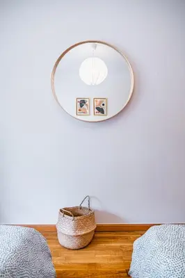 a mirror hanging on a wall next to a bed at Lovely apartment at the best location in Funchal in Funchal