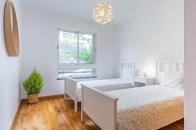 a bedroom with two beds and a window at Lovely apartment at the best location in Funchal in Funchal