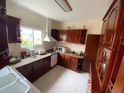 a kitchen with wooden cabinets and a sink and a window at Maria's House - São Jorge in Santana