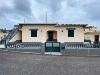 a house with a green door and a fence at Maria's House - São Jorge in Santana