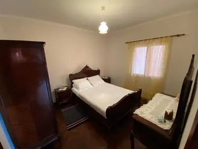 a bedroom with a bed and a dresser and a window at Maria's House - São Jorge in Santana