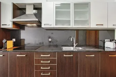 a kitchen with wooden cabinets and a sink at Costa Avila 2 in Caniço