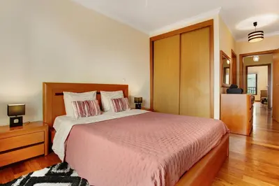 a bedroom with a large bed with a wooden headboard at Costa Avila 2 in Caniço