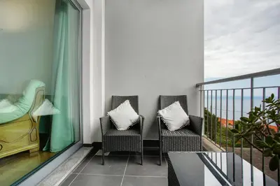 a balcony with two chairs and a table at Costa Avila 2 in Caniço