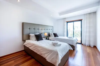 a bedroom with two beds and a large window at Baía da Luz - Sea View Luxury Apartment in Luz