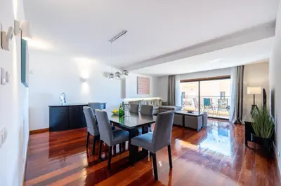 a dining room and living room with a table and chairs at Baía da Luz - Sea View Luxury Apartment in Luz