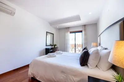 a bedroom with a large bed and a window at Baía da Luz - Sea View Luxury Apartment in Luz