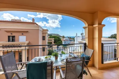 a patio with a table and chairs on a balcony at Baía da Luz - Sea View Luxury Apartment in Luz
