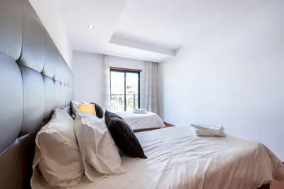a bedroom with two beds with white sheets and pillows at Baía da Luz - Sea View Luxury Apartment in Luz