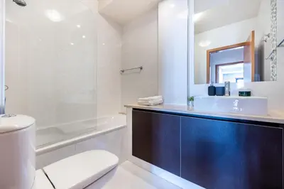 a bathroom with a toilet and a sink and a mirror at Baía da Luz - Sea View Luxury Apartment in Luz