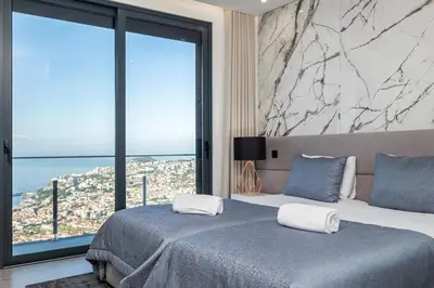 a bedroom with two beds and a large window at Villa Boa Nova Preta by LovelyStay in Funchal