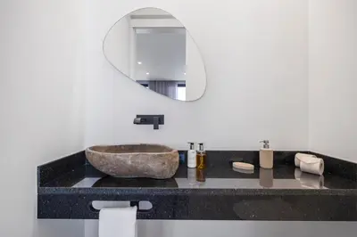 a bathroom with a stone sink and a mirror at Villa Boa Nova Verde by LovelyStay in Funchal