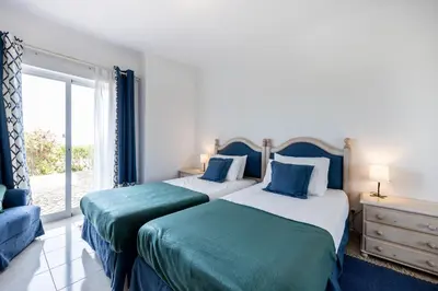 two beds in a room with a window at Townhouse da Amarela in Budens