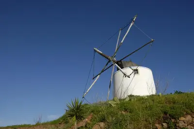 a windmill sitting on top of a hill at Townhouse da Amarela in Budens