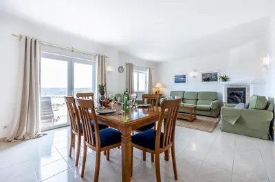a dining room and living room with a table and chairs at Townhouse da Amarela in Budens