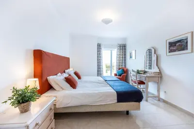 a bedroom with a bed and a desk and a chair at Townhouse da Amarela in Budens