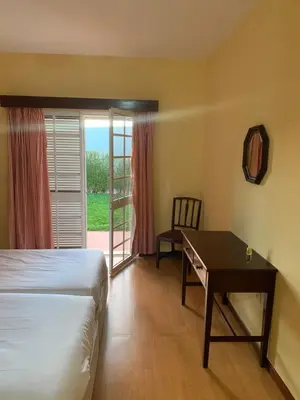 a bedroom with a bed and a desk and a window at Casa De Cha Prazeres in Prazeres