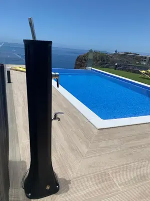 a swimming pool on the side of a house at Madeira Sea Sunshine with heated pool in Ribeira Brava