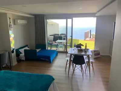 a living room with a couch and a table with chairs at Madeira Sea Sunshine with heated pool in Ribeira Brava
