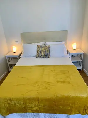 a bedroom with a large yellow bed with two night stands at Madeira Sea Sunshine with heated pool in Ribeira Brava