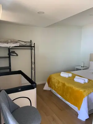 a bedroom with a bunk bed and a chair at Madeira Sea Sunshine with heated pool in Ribeira Brava