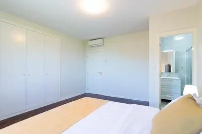 a white bedroom with a bed and a closet at Villa Pearl in Santana