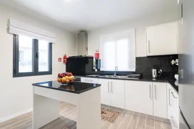 a kitchen with white cabinets and a bowl of fruit on a counter at Villa Pearl in Santana