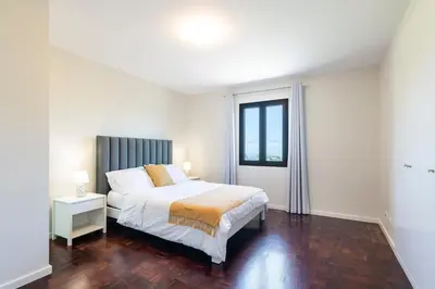 a white bedroom with a bed and a window at Villa Pearl in Santana