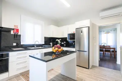 a white kitchen with a bowl of fruit on a counter at Villa Pearl in Santana