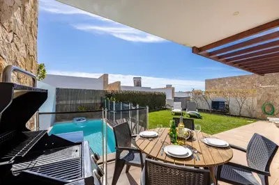a patio with a table and chairs and a grill at Villa Sagres Surf in Sagres