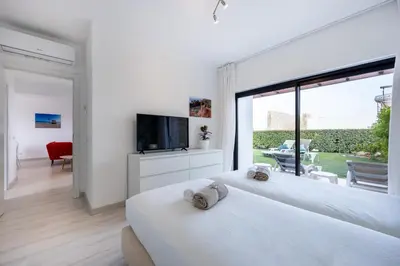 two white beds in a room with a large window at Villa Sagres Surf in Sagres