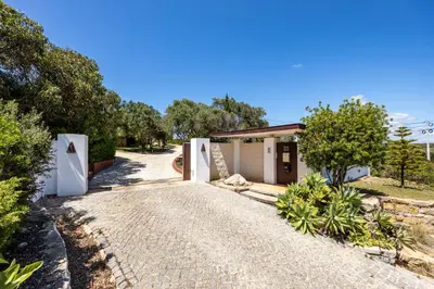 a gravel driveway leading to a small house at Villa Cercado, private swimming pool in Sagres