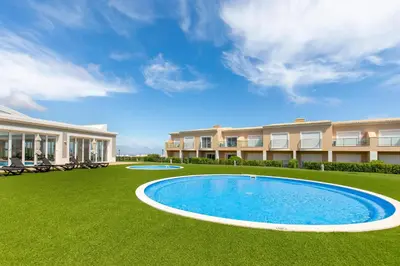 a large yard with a swimming pool in front of a building at Casa Makin at Boa Vista Golf Resort, Bayview Village in Lagos
