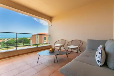a living room with a couch and a table and chairs at Casa Makin at Boa Vista Golf Resort, Bayview Village in Lagos