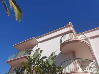 a building with balconies on the side of it at Top-floor 2 BR holiday home with sea view and pool in Luz