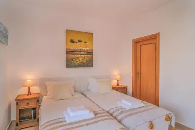 a bedroom with two beds and two lamps at Top-floor 2 BR holiday home with sea view and pool in Luz