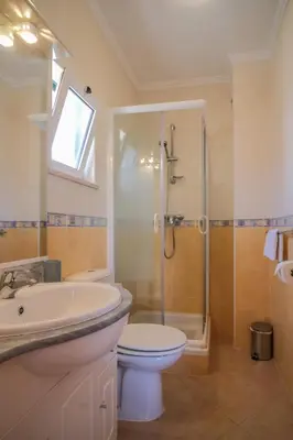 a bathroom with a sink and a toilet and a shower at Top-floor 2 BR holiday home with sea view and pool in Luz