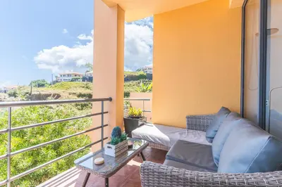 a balcony with a couch and a table at Vista Mar by Atlantic Holiday in Caniço