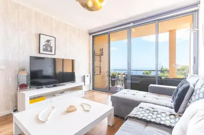 a living room with a couch and a tv at Vista Mar by Atlantic Holiday in Caniço