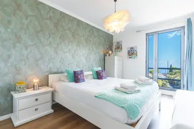 a bedroom with a white bed and a window at Vista Mar by Atlantic Holiday in Caniço