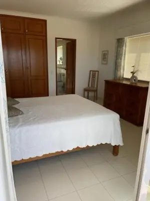 a bedroom with a white bed and a wooden dresser at Appartement Praia da Luz - 2 Personnes - Vue mer in Luz