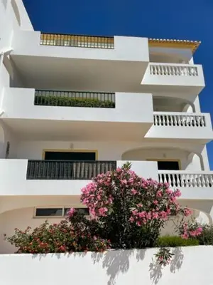 a tall white building with pink flowers on it at Appartement Praia da Luz - 2 Personnes - Vue mer in Luz